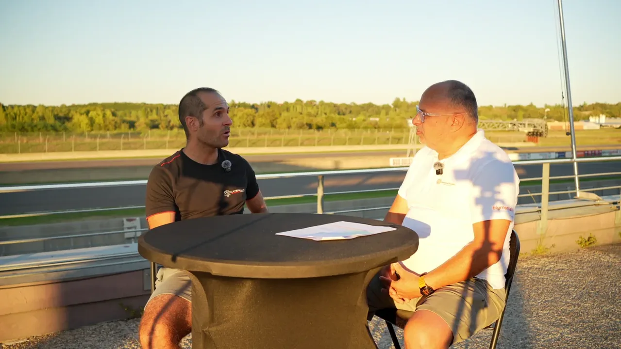 Dominique Palanque en entretien avec Vincent Beltoise, team manager, au bord de la piste au coucher du soleil