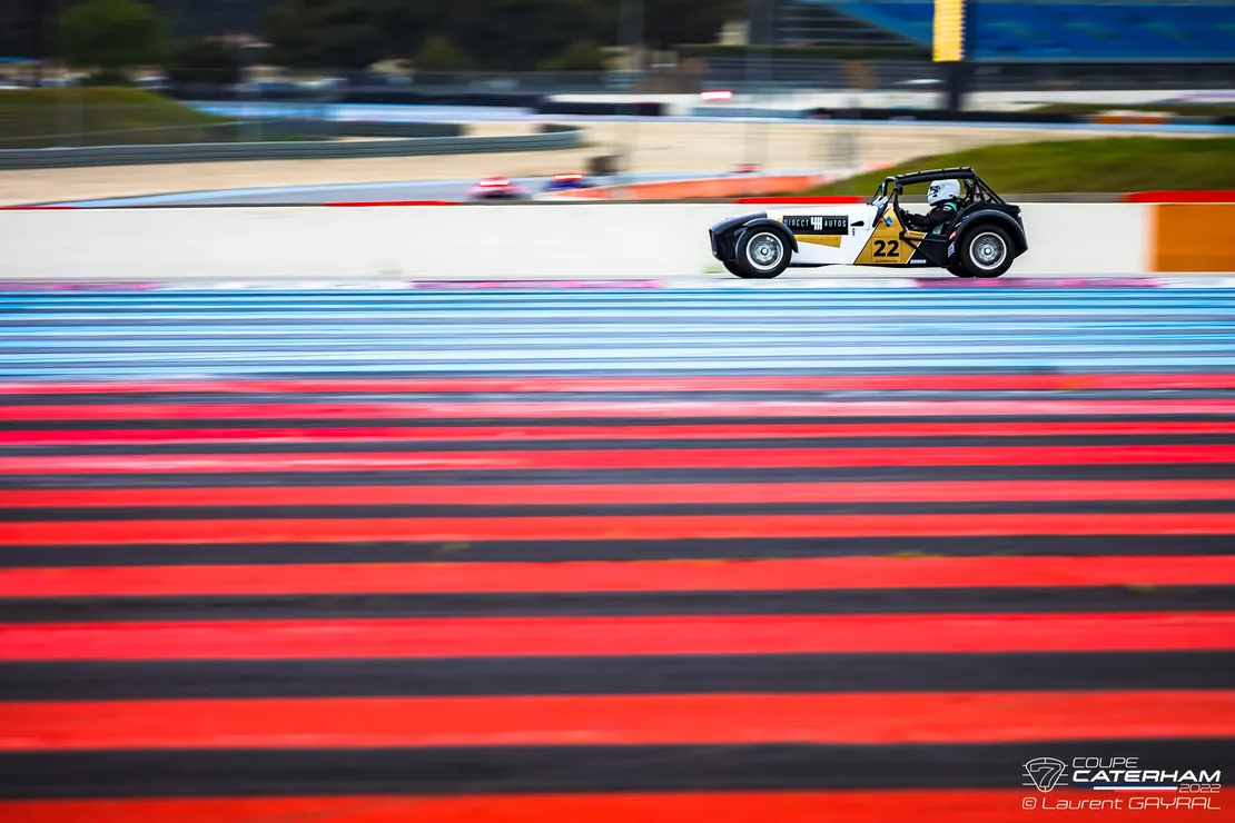 Une Caterham lancée à pleine vitesse devant les bandes rouges du circuit Paul Ricard