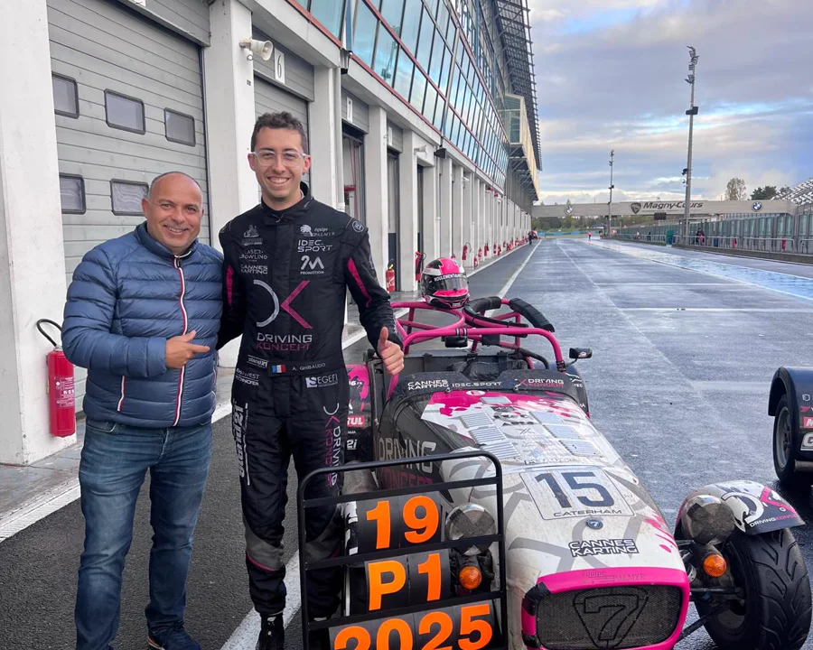 Dominique Palanque et un pilote dans la voie des stands, devant sa Caterham et le panneau P1 2025